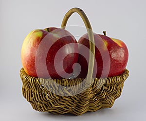 Two red apples in basket