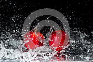Two red apples in water splash