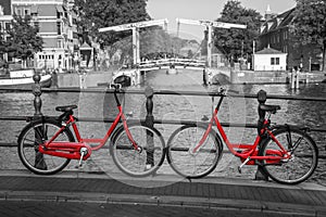 Two red bikes on the bridge over the channel in Amsterdam