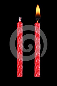 two red birthday candles isolated on black