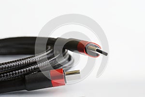 Two red-black usb type-c connectors and a black reinforced braided wire on a light background. Modern way to connect, transfer