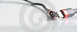 Two red-black usb type-c connectors with wires on a light background. Minimalism. A modern way to connect, transfer data and