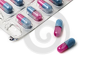 Two red and blue pills on table with package