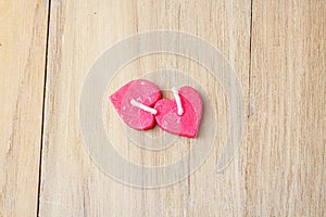 Two red candle heart shape on wooden board