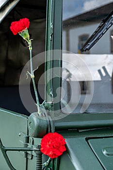 two red carnations decorating a military vehicle during the commemoration of April 25th in Portugal. RevoluÃÂ§ao dos Cravos photo