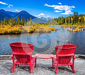 Two red chaise lounges on the lake