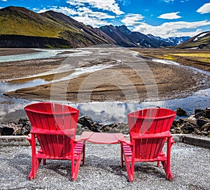 Two red chaise lounges for tourists