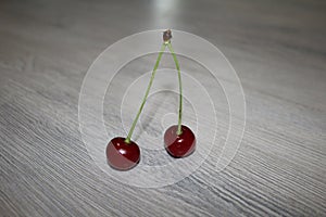 two red cherries on a green branch