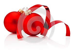 Two red Christmas baubles and curling paper Isolated on white background