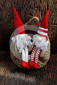 Two red Christmas gnome ornament relax together, cute handmade stuffed toy for decoration