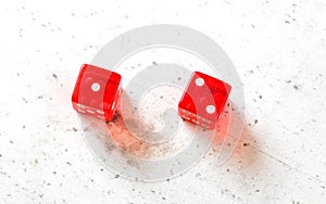 Two red craps dices showing Ace Deuce Number 1 and 2 overhead shot on white board photo