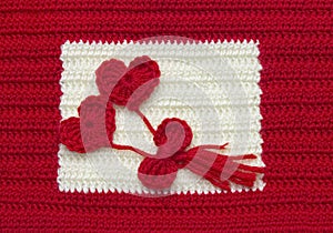 Two red crochet wool hearts and ribbon on crochet background. The concept for 14 February, romantic Valentine day, love affair,