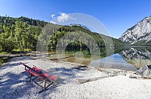 Two red deck chairs on Lake Leopoldsteiner near Eisenerz in Styria