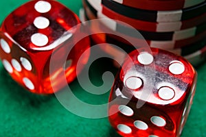 Two red dice cubes, lie on a green table