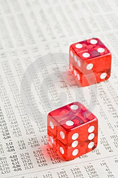 Two red dice on the financial newspaper