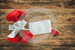 Two red dumbbell with a gift bow and blank paper tag