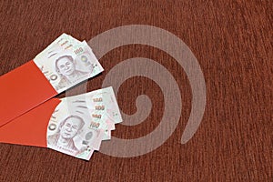 Two red envelope with thai baht bank as Chinese new year gift `angpao`.