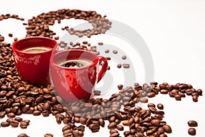 Two red espresso cups with coffee beans