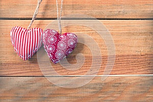 Two red fabric hearts on old wood background