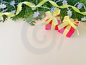 Two red gift boxes with yellow ribbon bow on beige background.