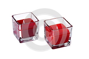 Two red glass candles, a pair of colourful tea lights isolated on white