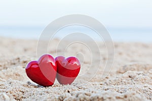 Two red hearts on the beach. Love