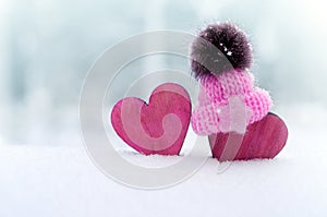 Two red hearts in cap on snow background. couple in love. Valentine`s Day. Red heart on snowy tree branch in winter. Holidays