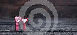 Two red hearts with clothespins on a wooden background. Valentine`s Day. Love