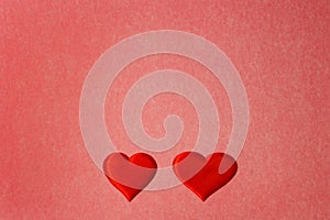 Two red hearts on a red color cardboard background. Copy space, Valentines Day concept