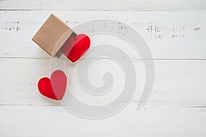 Two red hearts go out paper box on white wooden background - val