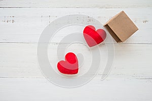 Two red hearts go out paper box on white wooden background - val