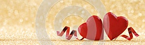 Two red hearts on golden background