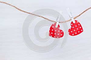 Two red hearts hanging on a thread on white wooden background. Valentine`s Day, love, wedding concept. Flat lay, top view
