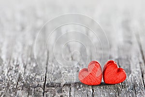 Two red hearts on old wood