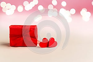 Two red hearts and red gift box on a white background with lights. Valentines day, love, romance, dating, gift present,