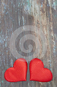 Two red hearts on the rustic wooden background.