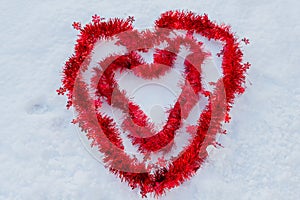 Two red hearts in the snow made of christmas wires