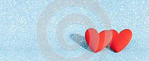 Two Red hearts valentine day greeting card. Bokeh blue background.