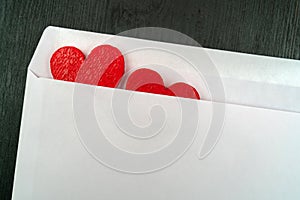 Two red hearts in a white envelope