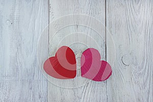 Two red hearts on white wooden background