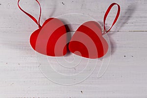 Two red hearts on white wooden background