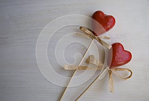 Two red hearts on a white wooden background