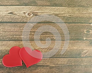 Two red hearts on a wooden background