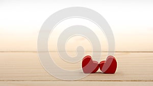 Two red hearts on a wooden table