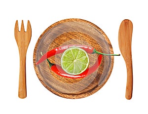 Two red hot chilli peppers and lime slice on wooden plate isolated on white