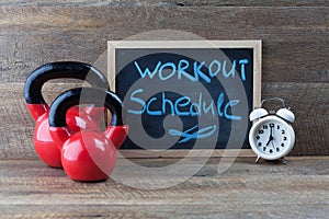 Two red kettlebells with vintage clock and blackboard.