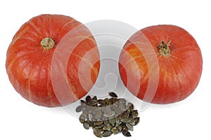 Two red kuri squash and a bunch of peeled seeds. Isolated on a white