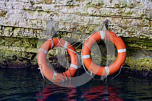 Two red lifesavers attached to a cenote wall in Greece