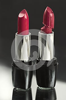 Two red lipsticks, perfect versus imperfect symbolic concept ide