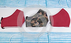 Two red masks and one military green one on a white background and hygienic masks